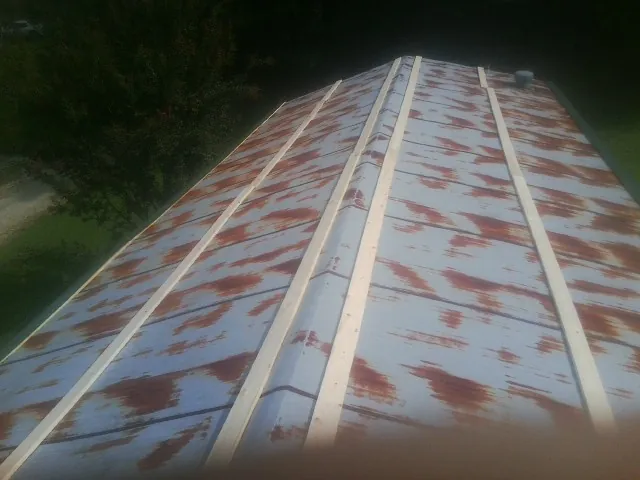 Rusted metal roof panels with new wood purlins before replacement — Storm Damage Roof Repair in Godley by Roofing Brothers